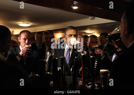 LE président AMÉRICAIN Barack Obama bénéficie d'une Guinness à Hayes Bar à Moneygall, dans le comté d'Offaly, lors de leur visite en Irlande. Banque D'Images