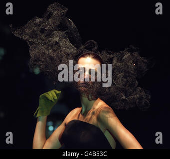 Le supermodèle Yasmin le bon modélise une création qui donne l'illusion de la fumée, par le designer Philip Treacy, lors du spectacle de la nuit dernière, dans le cadre de la Fashion week de Londres. Banque D'Images