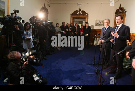 Le chancelier George Osborne (à droite), prenant la parole lors d'une conférence de presse à Stormont Castle, en tant que secrétaire d'État pour l'Irlande du Nord, Owen Patterson (2e à droite), regarde. Banque D'Images