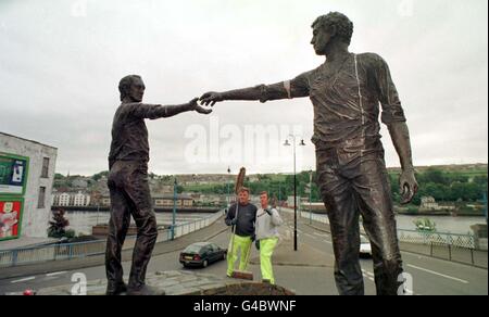 James McGriskin (à gauche) et Charlie McGinley, employés du conseil municipal de Derry, regardent les « mains à travers la statue de l'amitié du pont » qui se trouvent au bout du pont Craigavon à Londonderry le jour du référendum aujourd'hui (vendredi). Photo Barry Batchelor/PA. Banque D'Images