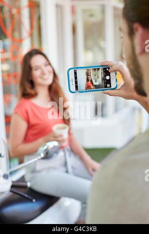 Parution du modèle. Personne prenant photo de jeune femme avec smartphone. Banque D'Images