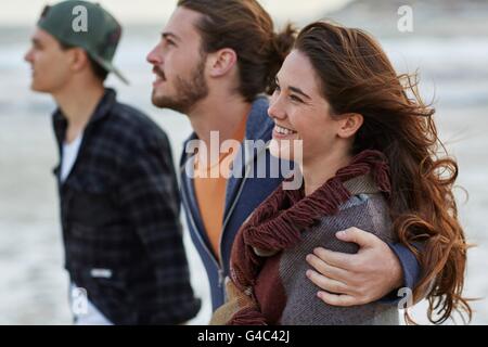 Parution du modèle. Jeune couple sur la plage avec un ami. Banque D'Images