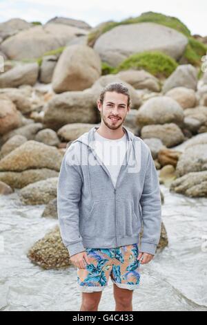 Parution du modèle. Jeune homme souriant sur la plage vers la caméra. Banque D'Images