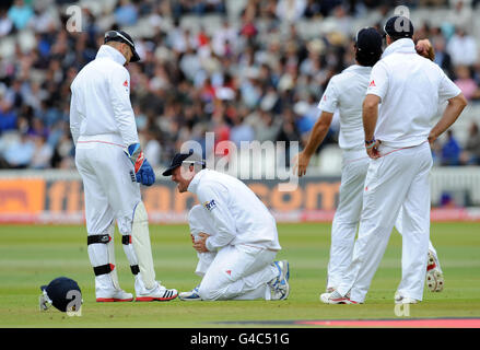 Le Graeme Swann d'Angleterre réagit après avoir été frappé sur le tibia tout en se mettant sur le slip lors du second npower Test match au Lord's Cricket Ground, Londres. Banque D'Images