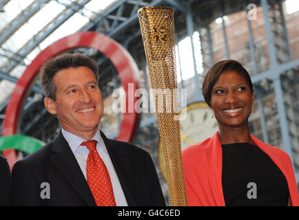 Le président de Londres 2012, Lord COE, et l'ancienne médaillée d'or olympique, Denise Lewis, lancent la flamme olympique, la nouvelle torche dorée qui sera portée par les 8,000 coureurs sur le relais de la torche de Londres 2012. À la gare de St Pancras à Londres. Banque D'Images