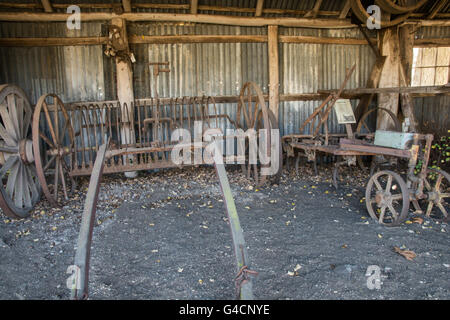 Vieux Outils agricoles tirés par des chevaux dans une vieille grange Banque D'Images