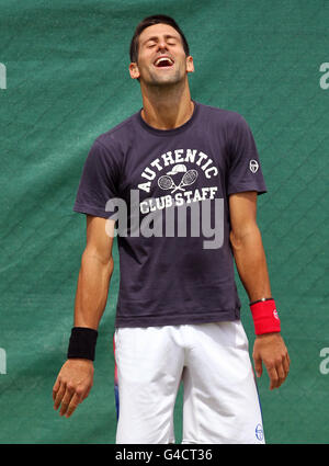 Le Novak Djokovic de Serbie partage une blague sur les courts d'entraînement le cinquième jour des Championnats de Wimbledon 2011 au All England Lawn tennis and Croquet Club, Wimbledon. Banque D'Images