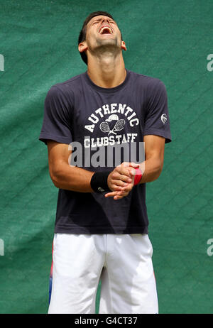 Le Novak Djokovic de Serbie partage une blague sur les courts d'entraînement le cinquième jour des Championnats de Wimbledon 2011 au All England Lawn tennis and Croquet Club, Wimbledon. Banque D'Images