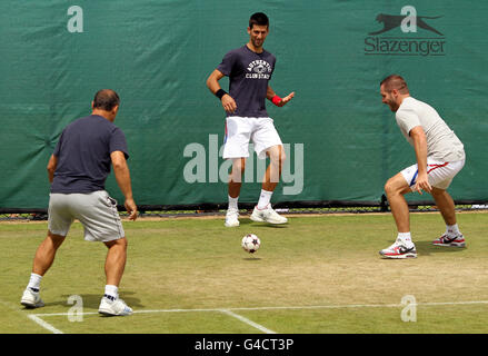 Le Novak Djokovic de Serbie joue au football avec ses entraîneurs sur les terrains d'entraînement le cinquième jour des Championnats de Wimbledon 2011 au All England Lawn tennis and Croquet Club, Wimbledon. Banque D'Images