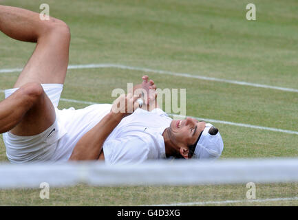 Rafael Nadal d'Espagne sourit après avoir glissé pendant qu'il pratique sur le court quinze pendant le douze jour des Championnats de Wimbledon 2011 au All England Lawn tennis Club, Wimbledon. Banque D'Images