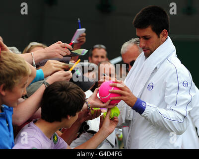 Le Novak Djokovic de Serbie signe des autographes après une séance d'entraînement sur le court 19 au cours du 12 e jour des Championnats de Wimbledon 2011 au All England Lawn tennis and Croquet Club, Wimbledon. Banque D'Images