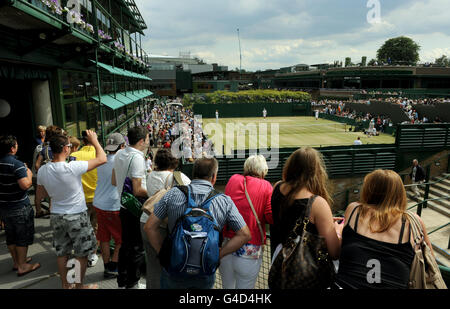 Les fans de tennis regardent l'action sur le court 19 au cours du 12 e jour des Championnats de Wimbledon 2011 au All England Lawn tennis Club, Wimbledon. Banque D'Images