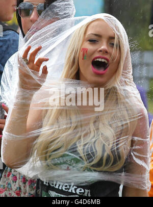 Un gardien de fête se tient à l'abri de la pluie au festival de musique T in the Park à Balado Park près de Kinross. Banque D'Images