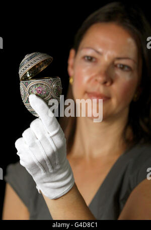 La conservatrice de la Collection royale Caroline de Guitaut examine un œuf en mosaïque, réalisé par le joaillier et orfèvre russe Peter Carl Faberge, qui a été commandé à l'origine par le tsar Nicholas II en 1914 et acquis par la reine Mary en 1933, dans le cadre de la nouvelle exposition Faberge à Buckingham Palace, Londres,Ouverture le samedi 23 juillet. Banque D'Images