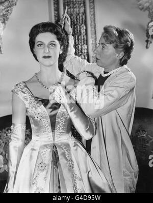 La cire de la princesse Margaret au musée Madame Tussaud, Marylebone Road London, qui est retouchée par le coiffeur Miss Vera Bland, de Scarborough, avant le week-end de Pâques. La princesse est montrée portant une robe de balle Norman Hartnell semblable à celle portée lors de sa tournée dans les Caraïbes. Il est en satin de couleur miel avec un panneau central intelligemment arrangé dans un ton plus profond courant à travers le corsage et la jupe. Banque D'Images