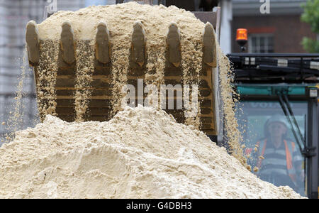 Le sable est livré au terrain de volley-ball de plage des Jeux Olympiques à Horse Guards Parade, Londres, en préparation pour le Visa FIVB Beach Volleyball International, l'épreuve d'essai de Londres 2012. Banque D'Images