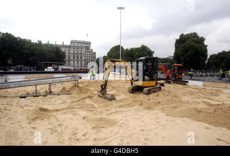 Le sable est livré au terrain de volley-ball de plage des Jeux Olympiques à Horse Guards Parade, Londres, en préparation pour le Visa FIVB Beach Volleyball International, l'épreuve d'essai de Londres 2012. Banque D'Images