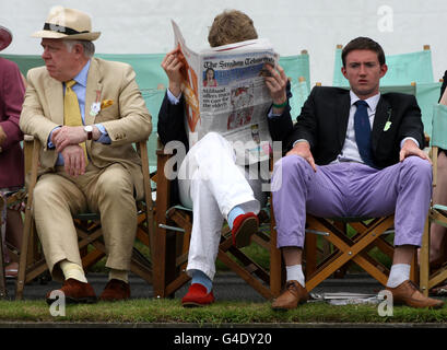 Des spectateurs masculins à la régate royale de Henley regardent l'aviron et lisent un journal du dimanche entre les courses de l'enclos des stewards pendant le cinquième jour de la régate royale de Henley, Henley-on-Thames. Banque D'Images