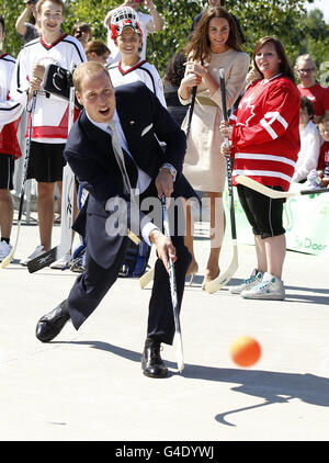 Le duc de Cambridge prend une photo avec un bâton de hockey alors que sa femme, la duchesse de Cambridge, observe lors d'une visite à la Somba K'e Civic Plaza à Yellowknife, dans les Territoires du Nord-Ouest. Banque D'Images