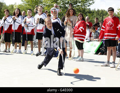 Le duc de Cambridge prend une photo avec un bâton de hockey alors que sa femme, la duchesse de Cambridge, observe lors d'une visite à la Somba K'e Civic Plaza à Yellowknife, dans les Territoires du Nord-Ouest. Banque D'Images
