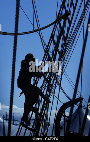 Un membre de l'équipage vérifie le gréement à bord de l'un des grands navires participant aux Tall Ships races 2011, amarrés à Greenock en Écosse. Banque D'Images