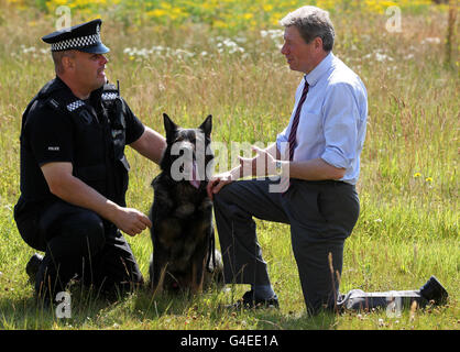 Le secrétaire du cabinet de la justice Kenny MacAskill avec le maître de chien PC George Lewandowski de la police de l'Écosse centrale et le chien Boris lors d'une visite au poste de police de Larbert où il a rencontré des officiers et du personnel de l'unité de protection publique et a discuté de son travail. Banque D'Images