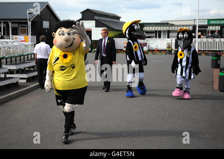 Courses hippiques - nuits d'Uttoxeter - Hippodrome d'Uttoxeter.La mascotte Burton Albion Billy Brewer (à gauche) et les mascottes du comté de Notts M. et Mme Magpie se promontent autour de l'hippodrome d'Uttoxeter Banque D'Images