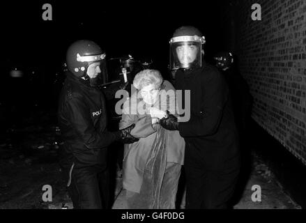 Une femme âgée est aidée par la police anti-émeute pendant les violences qui ont éclaté à Tottenham, dans le nord de Londres ce soir. Plus tôt, Mme Cynthia Jarrett est décédée lors d'un raid de la police à son domicile Banque D'Images