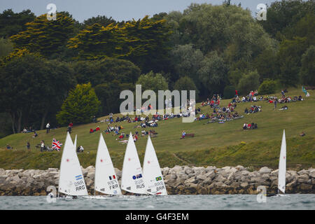 Les spectateurs et les membres de l'équipe de voile olympique britannique regardent Paul Goodison, un espoir olympique, participer à la course de médailles en classe laser lors du test des Jeux Olympiques de Londres 2012 et de la régate internationale à Weymouth. Banque D'Images