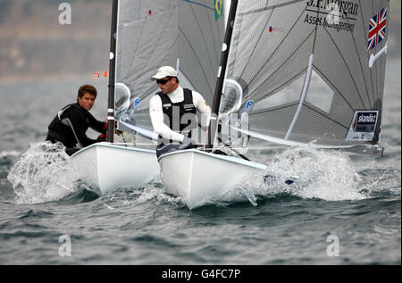 Ben Ainslie (au centre), en Grande-Bretagne, pratique le début de la campagne de fin de demain lors du test des Jeux Olympiques de Londres en 2012 et de la régate internationale de Weymouth. Banque D'Images