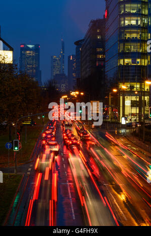 Theodor - Heuss-Allee avec voitures en circulation , nuit et la pluie en vue de le centre-ville avec la tour de la Commerzbank, Germa Banque D'Images