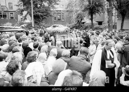 Les foules regardent le cercueil arriver à l'église paroissiale de Cheltenham pour le service funéraire de Brian Jones, ancien guitariste de 27 ans avec les Rolling Stones. Banque D'Images