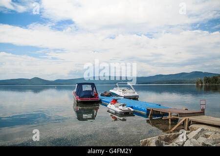 Les bateaux à moteur sont à quai au lac. ciel bleu, montagne et forêt Banque D'Images