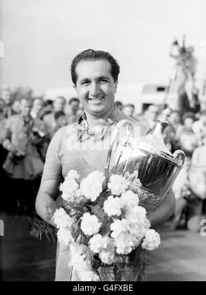 Courses automobiles - International Trophy Meeting - Silverstone.Le vainqueur Alberto Ascari tient le trophée et un bouquet après avoir revendiqué la victoire dans sa Ferrari Banque D'Images