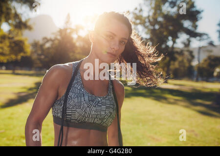 Portrait de santé de la jeune femme en soutien-gorge de sport avec une corde autour de son cou. Athlète féminin de prendre une pause de fitness t Banque D'Images