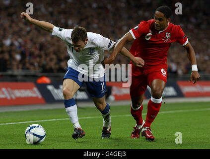 James Milner (à gauche) en Angleterre et Ashley Williams au pays de Galles se battent pour le ballon lors du match de qualification de l'UEFA Euro 2012 au stade Wembley, à Londres. Banque D'Images