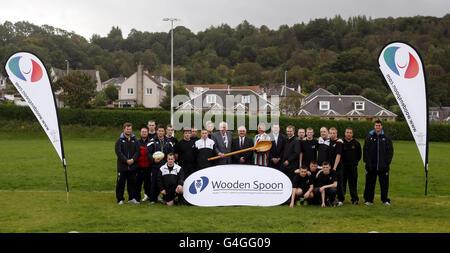 (Centre gauche à droite) Wooden Spoon membre du Comité national écossais Peter Brown, directeur du développement du rugby Greenock Wanderers Dougie Sloan, président du Comité national écossais Charlie Bryden, directeur régional du développement du Syndicat écossais de rugby Glen Tippett et responsable de l'éducation Inverclyde Council Terry Loughran avec les stars du rugby Fergus Thomson (à l'extrême gauche), Peter Murchie (à l'extrême droite) et l'entraîneur Grant Anderson (quatrième à gauche), sont des photos avec des enfants pour lancer le partenariat entre l'Union écossaise de rugby et le British Charity Wooden Spoon, au Lady Octavia Center, Greenock. Banque D'Images