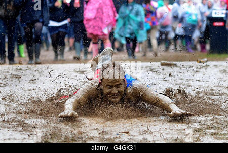 Le mauvais temps ne permet pas d'empêcher ce gardien de festival habillé comme Superman glissant dans la boue tout en appréciant les festivités du Leeds Festival 2011 qui s'est tenu à Bramham Park, Yorkshire. Banque D'Images