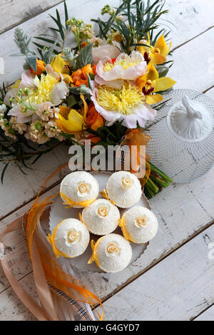 Beaux gâteaux et bouquet de mariée dans les tons orange Banque D'Images