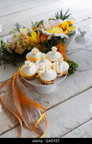 Beaux gâteaux et bouquet de mariée dans les tons orange Banque D'Images