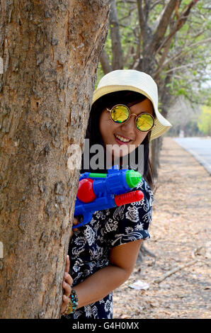 Portrait de femme thaïlandaise et jouer canon à eau toy à attendre en plein air inscrivez-vous avec Songkran Festival est célébré dans un Nouvel An traditionnel j Banque D'Images