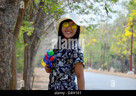 Portrait de femme thaïlandaise et jouer canon à eau toy à attendre en plein air inscrivez-vous avec Songkran Festival est célébré dans un Nouvel An traditionnel j Banque D'Images