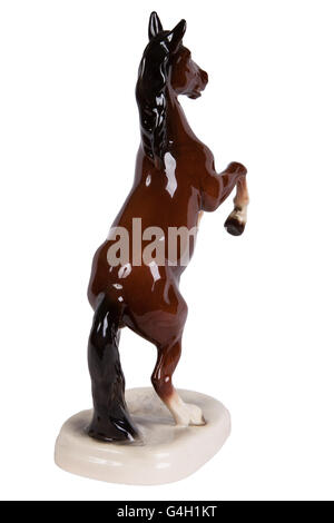 Figurine en céramique marron d'un cheval sur un fond blanc Banque D'Images