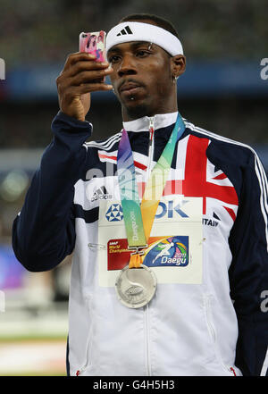 Le Phillips Idowu de Grande-Bretagne utilise son téléphone pour filmer le stade après avoir reçu sa médaille d'argent de la triple finale de saut masculin pendant le neuvième jour des Championnats du monde d'athlétisme de l'IAAF au stade Daegu à Daegu, en Corée du Sud. Banque D'Images