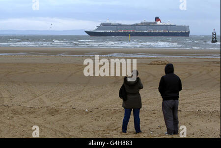 La compagnie de passagers Cunard, la reine Elizabeth, passe devant Antony Gormley, un autre endroit de Crosby Merseyside. Le paquebots de croisière arrime à Liverpool dans le cadre du Mersey River Festival 2011. Banque D'Images