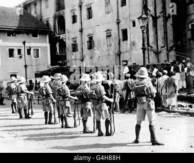 Des policiers britanniques et indiens ont fait le bilan des émeutiers de Patan à Dongri, Bombay, tandis que les soldats britanniques regardent, lors des émeutes hindoues et musulmanes de 1932. Banque D'Images