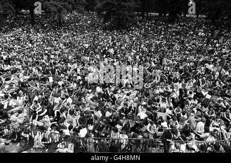 Une foule immense attend patiemment à Hyde Park, Londres, plusieurs heures avant le début d'un concert de l'après-midi par les Rolling Stones. Beaucoup avaient campé toute la nuit, chantant aux guitares. Banque D'Images