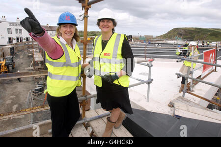 Le ministre du Tourisme Arlene Foster (à droite) avec Hilary McGrady, le directeur du National Trust pour l'Irlande du Nord, au sommet du centre de Causeway à Co Antrim, après que le ministre ait posé la dernière pierre lors d'une cérémonie de finition. Banque D'Images