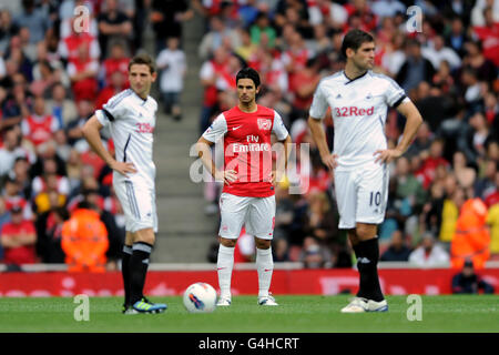 Mikel Arteta d'Arsenal s'aligne entre Joe de Swansea City Allen (l) et Danny Graham (r) Banque D'Images