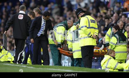 Roberto Martinez (à gauche), le directeur de Wigan Athletic, vérifie Hugo Rodallégla comme il est porté le terrain sur une civière Banque D'Images